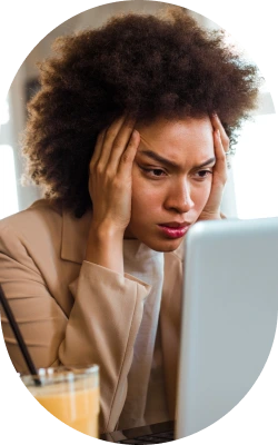 a woman looks worried staring at her laptop