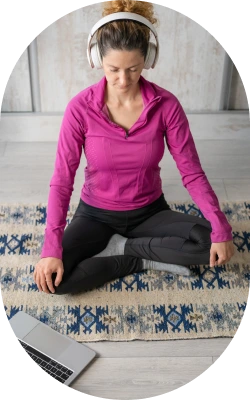 lady doing meditation while listening on her headphones